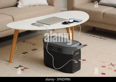 Indépendance énergétique et alimentation portable, électronique moderne rechargée à partir d'une station à haute capacité de batteries dans un salon pour une solution de vie hors réseau Banque D'Images