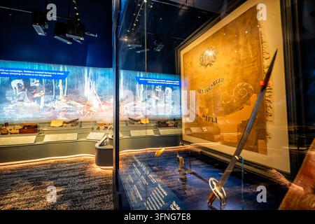 Artefacts de la guerre d'indépendance au musée de l'armée de Fort Belvoir | FORT BELVOIR, Va. — Une vitrine expose le drapeau de la Virginia Company de la Alexandria Rifle Company aux côtés d'épées, de pistolets et d'une selle de cheval datant de la chute de Charleston en 1780 dans une galerie du National Museum of the United States Army, photographiée le jeudi 25 septembre 2026. L'exposition fait partie de la galerie Founding the Nation sur le North Post de Fort Belvoir dans le comté de Fairfax, en Virginie, au sud de Washington, D.C. Les forces du général britannique Sir Henry Clinton, composées de plus de 13 000 soldats, ont assiégé Charleston, en Caroline du Sud, forçant M Banque D'Images