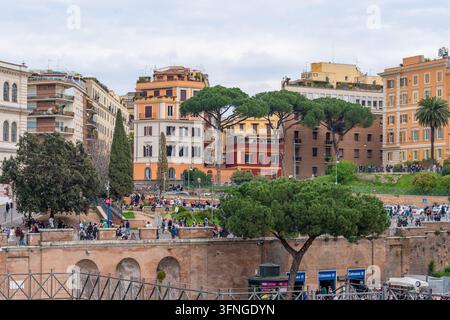 Rome, Italie - 09 mars 2025 : Une scène animée à Rome avec des bâtiments historiques, des arbres luxuriants et des piétons se promenant le long d'une promenade pittoresque Banque D'Images