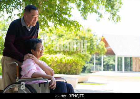 Les couples âgés ou les aidants prennent soin du patient en fauteuil roulant. Concept d'un retraite heureuse avec des soins d'un aidant et des économies et des seniors Banque D'Images