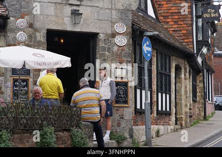 Hommes devant le pub Old Bell sur une façade en pierre et en bois à Rye, en Angleterre. Banque D'Images