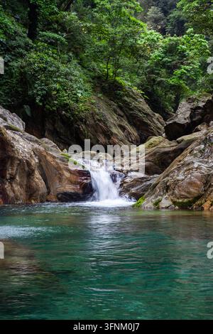 Cascade de la rivière Sanzhanxi à Taroko. Bassin turquoise entouré de falaises rocheuses. Forêt luxuriante recouvrant les parois du canyon. Banque D'Images