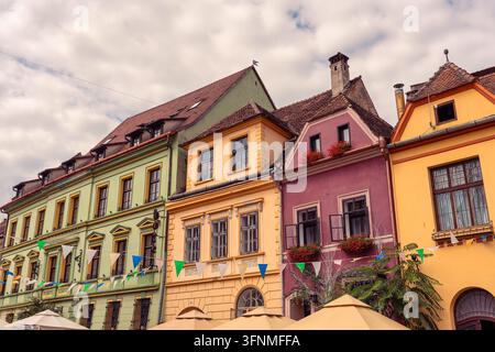 Façades historiques colorées et toits traditionnels en tuiles dans la vieille ville de Sighisoara, Roumanie Banque D'Images