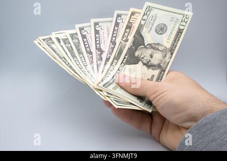 Des dollars tenus dans la main d'un homme. Banque D'Images
