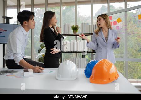 Groupe de cadres et ingénieurs asiatiques travaillant et faisant du brainstorming au bureau. Équipe de construction compétente discutant lors d'une réunion. Équipe Ar Banque D'Images