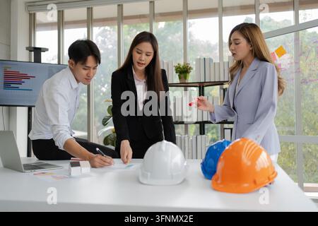Groupe de cadres et ingénieurs asiatiques travaillant et faisant du brainstorming au bureau. Équipe de construction compétente discutant lors d'une réunion. Équipe Ar Banque D'Images