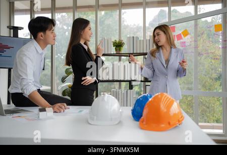 Groupe de cadres et ingénieurs asiatiques travaillant et faisant du brainstorming au bureau. Équipe de construction compétente discutant lors d'une réunion. Équipe Ar Banque D'Images