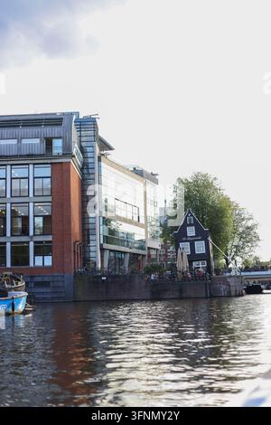 Amsterdam, Pays-Bas – 1er octobre 2026 : Les maisons traditionnelles des canaux et les bateaux amarrés créent un paysage urbain automnal classique. Banque D'Images