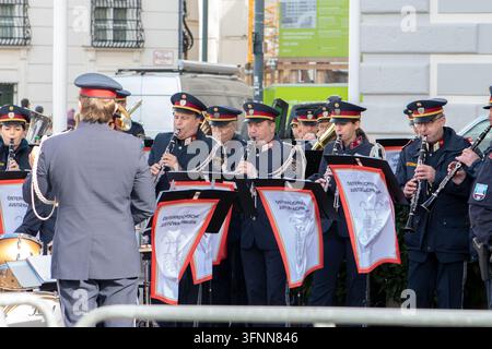 VIENNE, AUTRICHE, 26 octobre 2025 : Des musiciens en uniforme jouent en plein air tandis qu'un chef d'orchestre fait face à l'orchestre. Banque D'Images