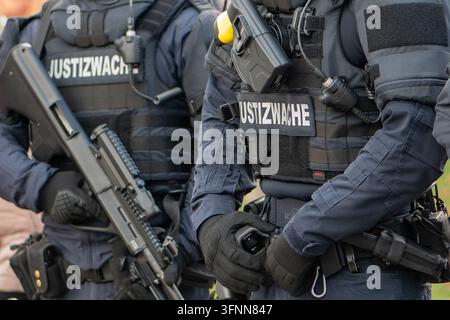 VIENNE, AUTRICHE, 26 octobre 2025 : Des agents pénitentiaires armés portant des uniformes tactiques et des gilets marqués Justizwache se tiennent à l'extérieur. Banque D'Images