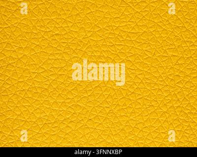 Macro détaillée d'une surface en cuir jaune doré vif présentant une texture fine en réseau craquelé et un éclairage dimensionnel doux. Banque D'Images