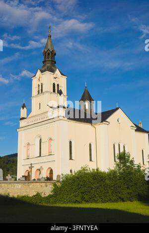 Vue en contre-plongée de l'église Saint-Nicolas avec clocher sous un ciel bleu à Bohinjska Bistrica, Slovénie. Banque D'Images