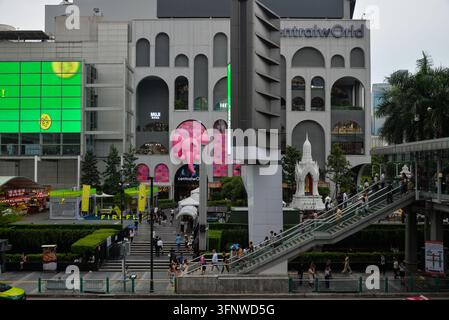 BANGKOK, THAÏLANDE – 5 JUILLET 2026 : Centre commercial CentralWorld dans le centre de Bangkok, avec des escaliers mécaniques extérieurs, un autel spirituel thaïlandais et des visiteurs à l'extérieur Banque D'Images