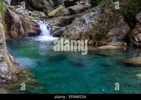 Rivière Sanzhanxi dans le parc national de Taroko, à Taïwan. Une petite cascade débouche dans un bassin turquoise clair. De gros rochers et des falaises entourent l'eau. Banque D'Images