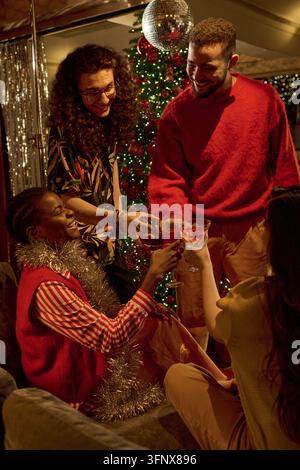 Divers amis portant un toast avec des boissons lors d'une fête de Noël Banque D'Images