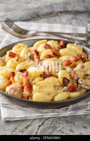 Gnocchi carbonara une variante réconfortante du plat de pâtes classique gros plan sur l'assiette sur la table. Vertical Banque D'Images
