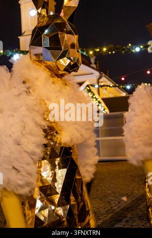 Bialystok, Pologne – 4 décembre 2025 : Artiste de rue vêtu d’un costume de lapin miroir doré avec un col en tulle blanc au marché de Noël près du To Banque D'Images