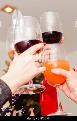 Famille ou amis célébrant Noël avec un toast au vin. Banque D'Images