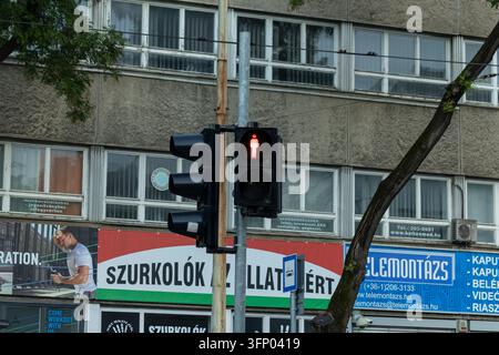 Hongrie, Budapest 2021 05 30 : Feu piéton montrant le signal homme rouge, gros plan avec façade urbaine en arrière-plan, lumière de jour Banque D'Images