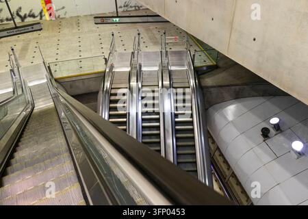 Hongrie, Budapest 2021 05 30 : Vue en hauteur des escaliers mécaniques d'une station de métro moderne avec un éclairage intérieur vif, des structures architecturales en béton et c Banque D'Images