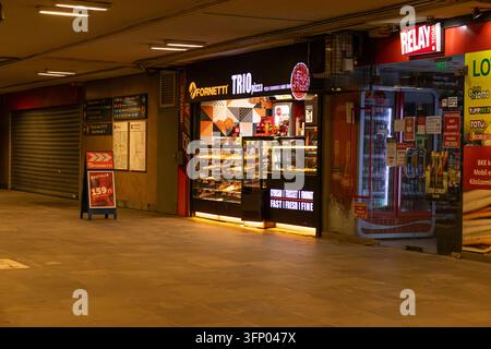 Hongrie, Budapest 2021 05 30 : boulangerie Fornetti et magasin Relay dans un passage souterrain de métro avec un éclairage artificiel chaud, prise de vue au niveau des yeux, horizontal Banque D'Images