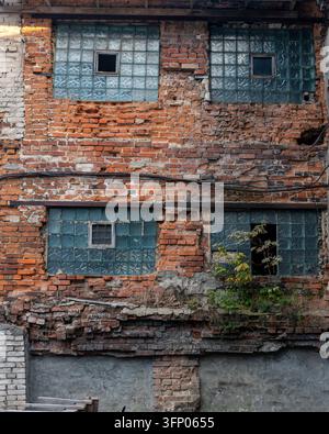 Façade de bâtiment en briques rouges patinées avec fenêtres en blocs de verre Banque D'Images