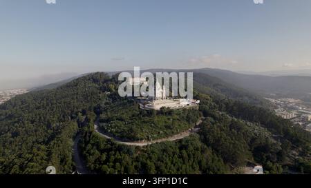 Vue aérienne du Sanctuaire du Sacré-Cœur de Jésus au sommet d'une colline boisée avec des routes sinueuses et un environnement urbain à Viana do Castelo, Viana do Banque D'Images