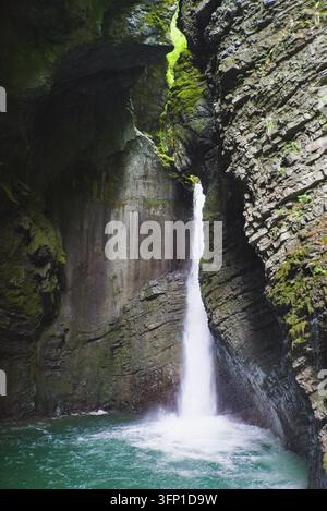 Cascade de cascade tombant dans une piscine turquoise claire à l'intérieur du canyon étroit des gorges de Tolmin en Slovénie. Banque D'Images