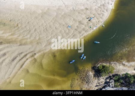Vue aérienne de personnes faisant du kayak et du paddle dans les eaux peu profondes de l'estuaire de Cudgera Creek, avec des bancs de sable ondulés et une eau claire à Hastings P Banque D'Images