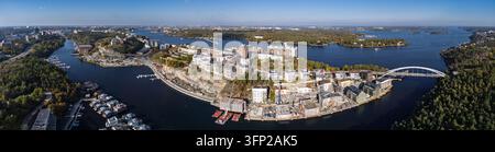 Vue aérienne du quartier résidentiel moderne de Kvarnholmen avec des chantiers de construction, des grues et des bâtiments riverains entourés par la mer Baltique à Kv Banque D'Images