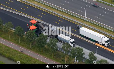 Nieuwegein, Pays-Bas – 16 juin 2026 : Vue aérienne des travaux de construction routière sur une autoroute avec une poseuse d’asphalte et un camion, à côté d’un chemin cyclable Banque D'Images