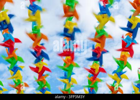 Photo en gros plan dynamique mettant en scène une collection de moulinets vibrants contre un ciel lumineux et nuageux, soulignant le mouvement rapide avec une légère mise au point pour un effet abstrait Banque D'Images