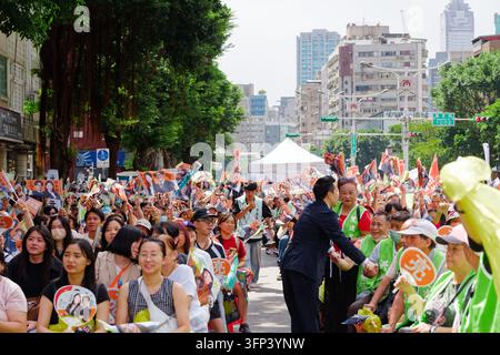 Taipei, Taïwan – 03 oct. 2026 : Un ancien conseiller serre la main des soutiens lors de l’ouverture d’un siège de campagne à Taipei, une foule fait signe au candidat. Banque D'Images