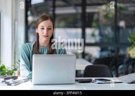 Femme milléniale confiante travaillant dans un bureau créatif Banque D'Images