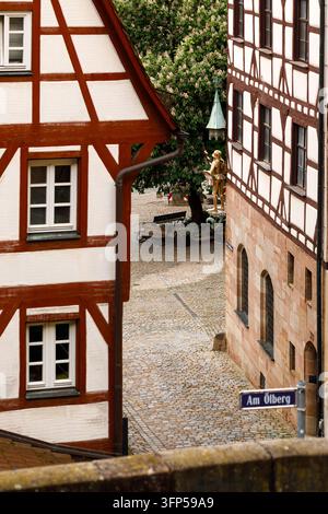 Maison à colombages avec toit traditionnel en tuiles rouges dans une rue étroite du centre historique de Nuremberg, Bavière, Allemagne Banque D'Images