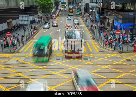 Intersection dans le centre de Hong Kong. Beaucoup de voitures, de taxis, de bus et de piétons Banque D'Images
