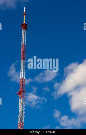 Tour de télécommunication rouge et blanche contre un ciel bleu, infrastructure de réseau sans fil et transmission de signaux. Banque D'Images