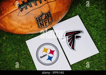 PENNSYLVANIA, ÉTATS-UNIS, 7 SEPTEMBRE 2026 : Concept de match NFL des Pittsburgh Steelers contre les Atlanta Falcons avec les logos des équipes imprimés sur du papier blanc à côté d'un l Banque D'Images