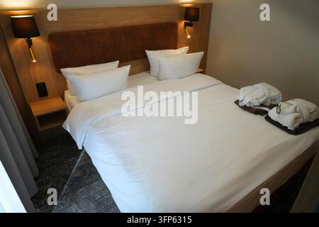 Lit king-size dans un hôtel polonais. Lit double dans une jolie chambre d'hôtel en Pologne. Banque D'Images