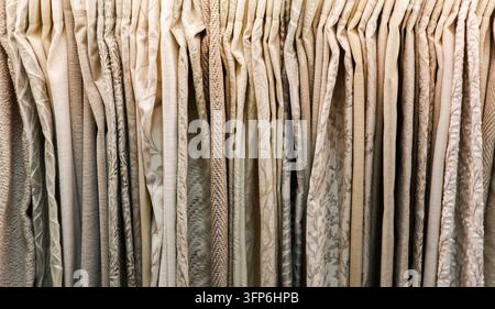 Échantillons de tissus présentant différentes textures et motifs dans des tons beige et crème, idéaux pour les draperies et les tissus d'ameublement Banque D'Images