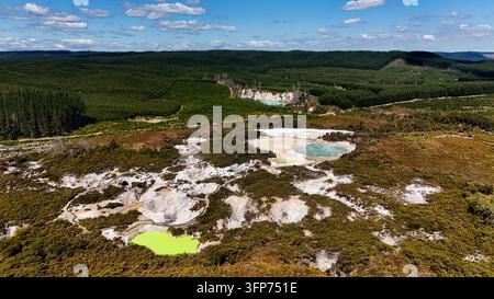 Vue aérienne des bassins géothermiques et du paysage volcanique du Wonderland thermique de Waiotapu, présentant des eaux riches en minéraux vibrantes et les berges environnantes Banque D'Images