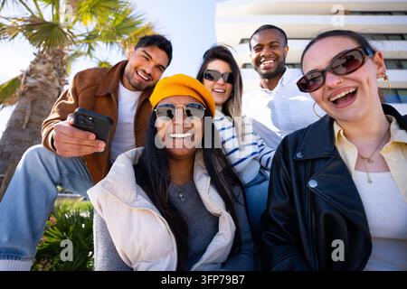 Groupe divers d'amis souriant en plein air dans un cadre moderne Banque D'Images