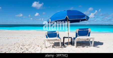Deux chaises de plage et parasol bleu à Shoal Bay, Anguilla Banque D'Images