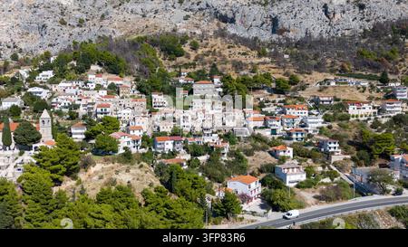 Vue aérienne du village historique de Mimice sous les montagnes calcaires de Dalmatie, en Croatie Banque D'Images