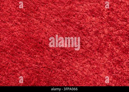 Cette photographie en gros plan met en vedette une surface en daim rouge vif avec un velours dense et doux, mettant en lumière des tons cramoisis riches et une texture veloutée tactile Banque D'Images