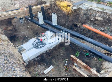Rénovation et remplacement d'une conduite de gaz dans une rue urbaine. Le chantier de construction montre une tranchée creusée avec des travaux de services souterrains comme agin Banque D'Images