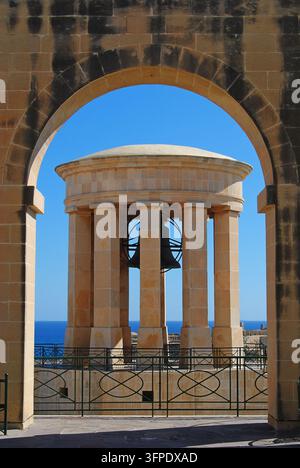 Mémorial de la Cloche de la Victoire encadré par une arche de pierre à La Valette, Malte Banque D'Images