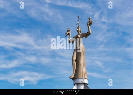 Une statue d'une femme se dresse sur un piédestal et soulève deux petites figures contre le ciel nuageux, statue d'Imperia dans le port de Constance sur le lac de Constance Banque D'Images