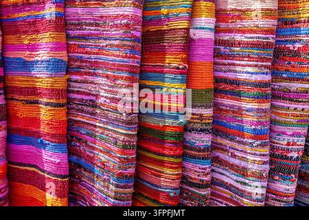 Textiles tissés à la main vibrants empilés en couches colorées mettant en valeur un riche mélange de motifs lumineux, de textures et d'artisanat traditionnel Banque D'Images
