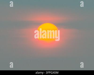 Le soleil couchant illumine des nuages brumeux en Indonésie. Banque D'Images